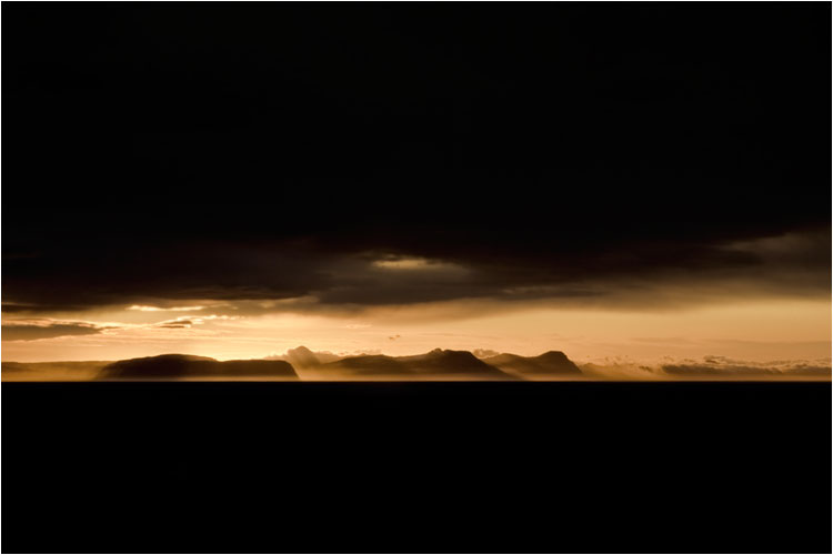 Die letzen Sonnenstrahlen finden ihren Weg unter der dichte Wolkendecke. Im Norden