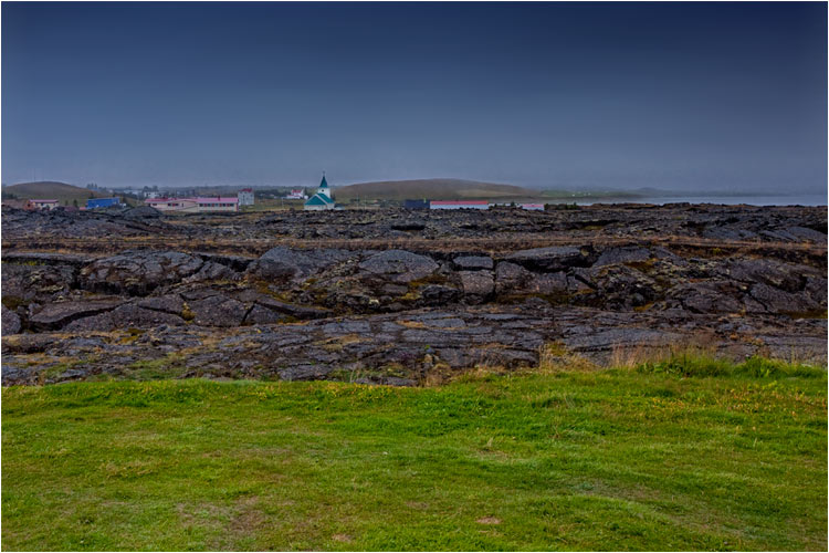 Ein Lavafeld zwischen Dorf und Wiesen, bei Reykiahlíð