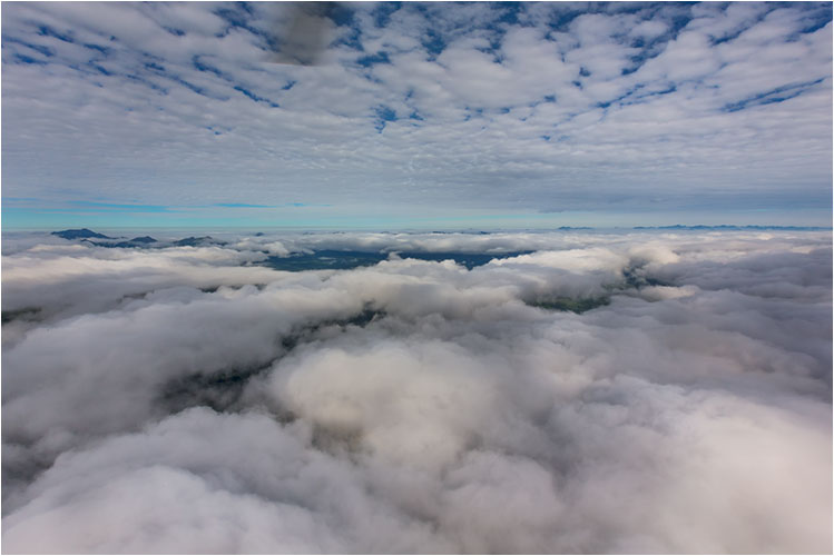 Helikopterflug zwischen zwei Wolkenschichten