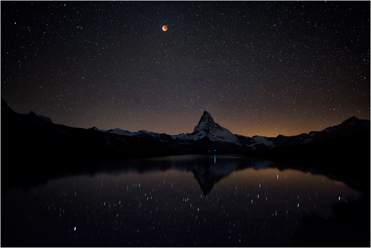 Oktober, Totale Mondfinsternis, auch als Blutmond bekannt, über dem Matterhorn.