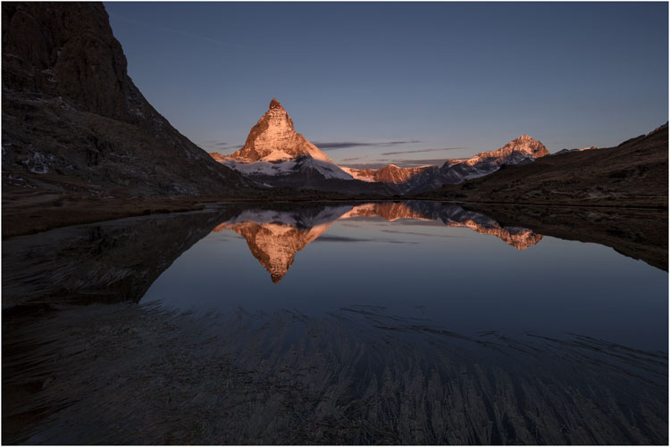 Die warmen Sonnenstrahlen erhellen das Matterhorn.