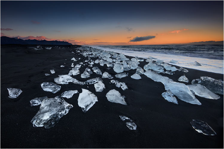 Kontrast zwischen weisse Eisblöcke und schwarzem Strand